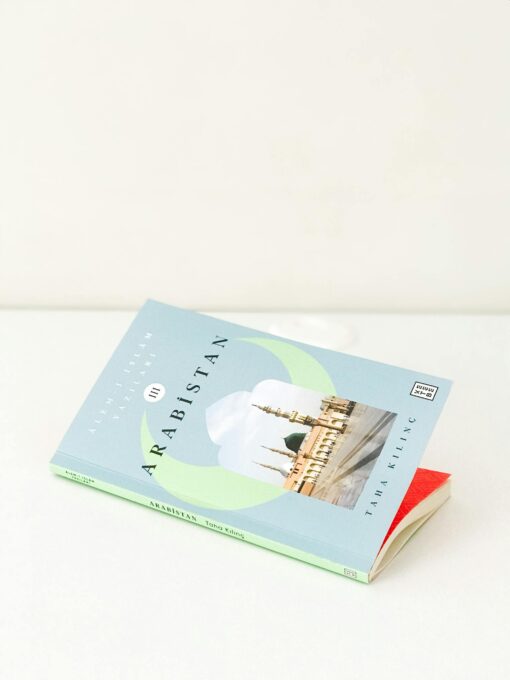A softcover book titled 'Arabistan' placed on a clean, white surface with ample copy space.